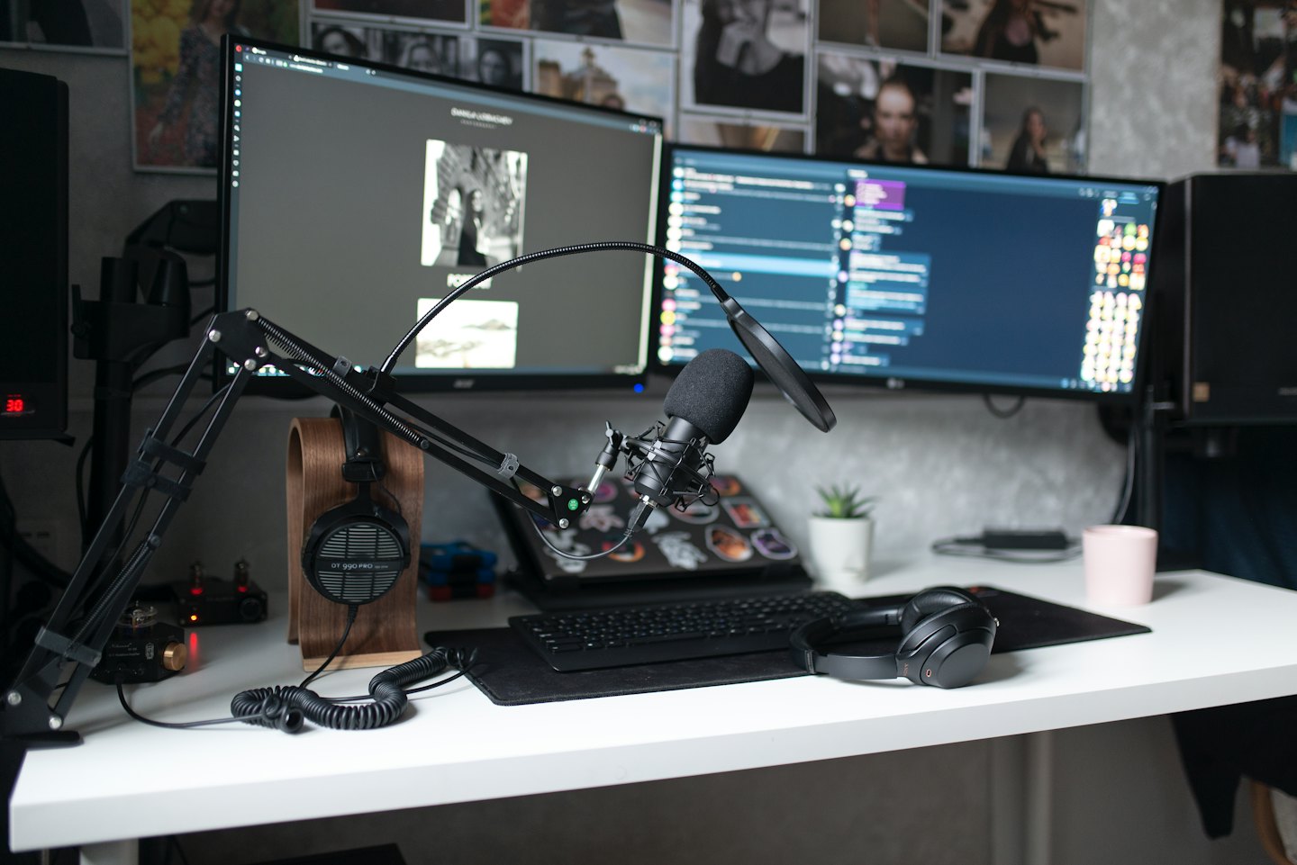 Desk with dual monitors, microphone, and headphones for content creation.